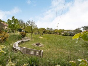 A grassy backyard with a wooden bench, a swing set, and a fire pit. - 1 Bed in Ventnor (oc-85978) (Chale Green)
