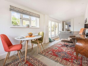 A dining area with a round table, chairs, and a rug. - 1 Bed in Ventnor (oc-85978) (Chale Green)