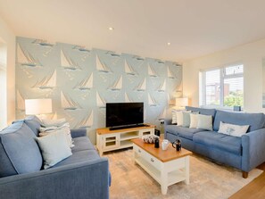 A living room with a TV, two sofas, a coffee table, and a patterned wall. - 1 Bed in Hythe (oc-89968) (Hythe)