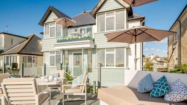 A coastal house with a balcony, outdoor seating, and a view of neighboring houses. - 1 Bed in Hythe (oc-89969) (Hythe)