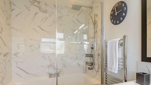 A bathroom with a glass-enclosed shower, a white sink, a towel rack, and a clock on the wall. - 1 Bed in Hythe (oc-89969) (Hythe)