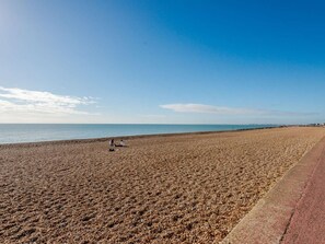 A beach with pebbles, a clear sky, and a calm sea. - 1 Bed in Hythe (oc-89970) (Hythe)