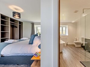 A modern bedroom with a large bed, bedside tables, and a wardrobe. - 4 Bed in Saltash (oc-93634) (Saint Mellion)