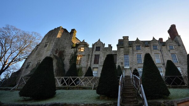 A historic stone building with a central tower, symmetrical windows, and a staircase leading to the entrance. - 2 Bed in Brecon (oc-51153) (Llandefalle)
