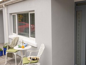 Eine weiße Außenwand mit einem Fenster und einer Tür mit der Aufschrift 'RAMBLERS TREAT'.