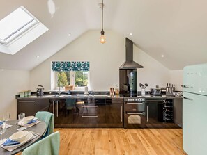 A modern kitchen with a skylight, a large island, a built-in oven, and a wine rack. - 1 Bed in Melton Mowbray (oc-93068) (Kirby Bellars)