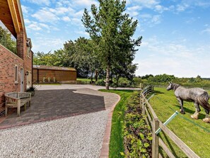 A stable with a horse, a paved area, and a wooden fence. - 1 Bed in Melton Mowbray (oc-93068) (Kirby Bellars)