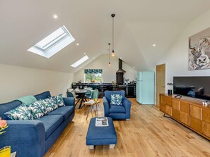 A spacious living area with a high ceiling, skylights, a dining table, sofas, and a kitchen in the background. - 1 Bed in Melton Mowbray (oc-93068) (Kirby Bellars)