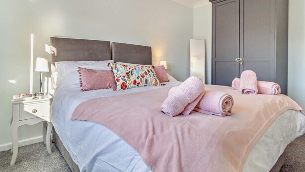 Una camera da letto con un letto, comodini, un armadio e asciugamani.