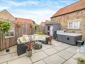 A patio with outdoor furniture, a hot tub, and a stone building with a tiled roof. - 1 Bed in Richmond (oc-93264) (Hudswell)