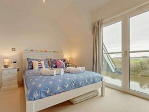 A bedroom with a bed, bedside tables, and a large window. - 4 Bed in Newport (oc-93249) (Newport)