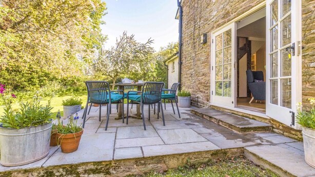 A stone building with a patio, outdoor seating, and a door leading to an interior space. - 3 Bed in Hereford (oc-93304) (Bodenham)