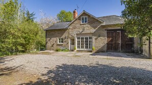 A stone house with a gravel driveway, a wooden door, and a window. - 3 Bed in Hereford (oc-93304) (Bodenham)