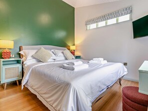 A hotel room with a bed, bedside tables, a lamp, and a TV. - 2 Bed in Truro (oc-93310) (Porthtowan)
