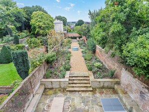 A garden with a stone pathway leading to a seating area with a table and chairs. - 6 Bed in Ludlow (oc-93327) (Ludlow)