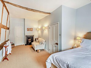 A bedroom with a wooden ceiling beam, a fireplace, a bed, a sofa, and wall-mounted lighting. - 6 Bed in Ludlow (oc-93327) (Ludlow)