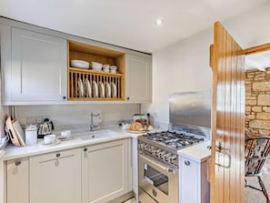 A kitchen with a built-in oven, a gas stove, and a wooden shelf above the sink. - 1 Bed in Chipping Campden (oc-93393) (Chipping Campden)