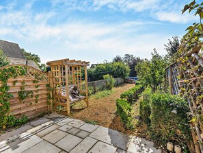 A garden with a wooden pergola, a stone pathway, and a variety of plants. - 1 Bed in Chipping Campden (oc-93393) (Chipping Campden)