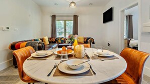 A dining area with a round table, chairs, and a sofa. - 3 Bed in King's Lynn (oc-93412) (Middleton)
