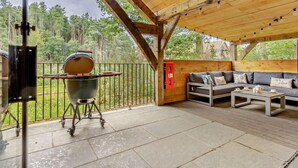 A covered outdoor area with a barbecue grill, a sofa, and a table. - 3 Bed in King's Lynn (oc-93412) (Middleton)