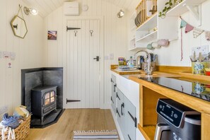 Uma cozinha compacta com fogão embutido, armários de madeira e lava-louças.