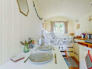 A compact room with a bed, a small kitchenette, and a dining area with a table set for two. - 1 Bed in Hereford (oc-93441) (Little Dewchurch)