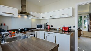 A modern kitchen with white cabinetry, a stainless steel sink, and a wooden countertop. - 2 Bed in Christchurch (oc-93458) (Christchurch)