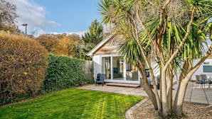A house with a patio, a lawn, and a tree. - 2 Bed in Christchurch (oc-93458) (Christchurch)