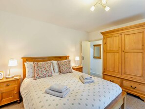 A bedroom with a bed, nightstands, a wooden wardrobe, and a mirror. - 2 Bed in Penrith (oc-93492) (Glenridding)