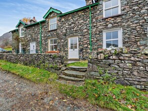 A stone building with a traditional design, featuring a front door, windows, and a stone wall. - 2 Bed in Penrith (oc-93492) (Glenridding)