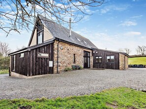 A building with a stone facade, a sloped roof, and a gravel driveway. - 7 Bed in Bideford (oc-93523) (Weare Giffard)