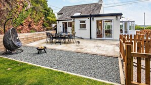 A house with a patio, a swing chair, and a dog. - 2 Bed in Llandudno Junction (oc-93622) (Bryn Pydew)