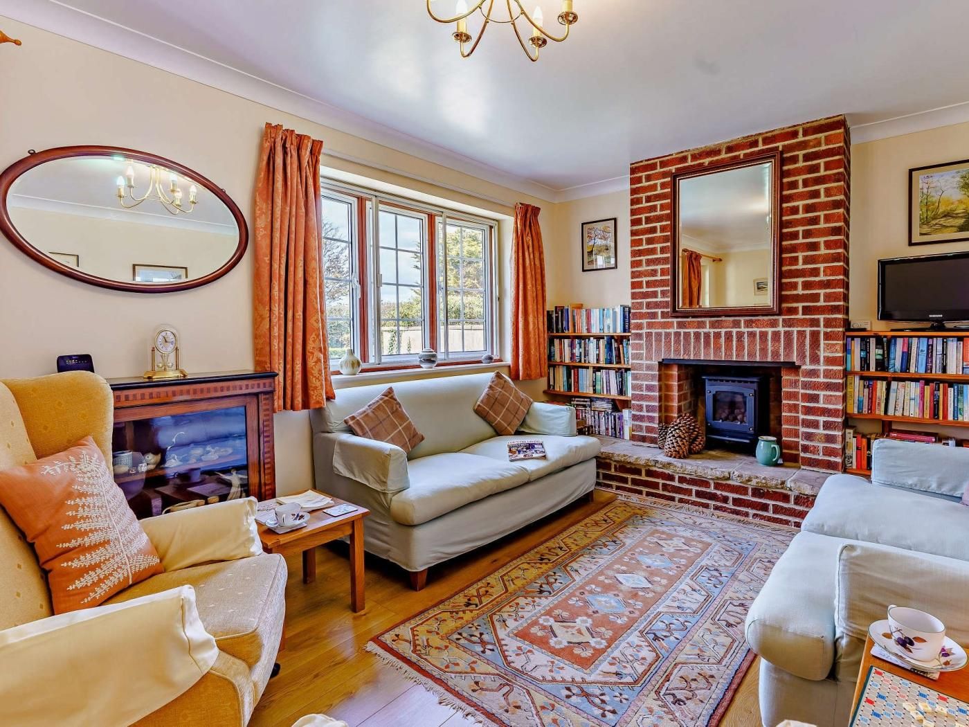 A cozy living room with a fireplace, bookshelves, and a comfortable seating area.