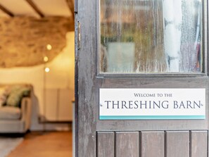 A wooden door with a sign that reads 'Welcome to the Threshing Barn.' - 1 Bed in Yelverton (oc-93333) (Yelverton)