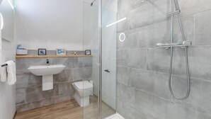 A modern bathroom with a glass shower enclosure, a white sink, and a toilet. - 2 Bed in Appledore (oc-gable) (Appledore)