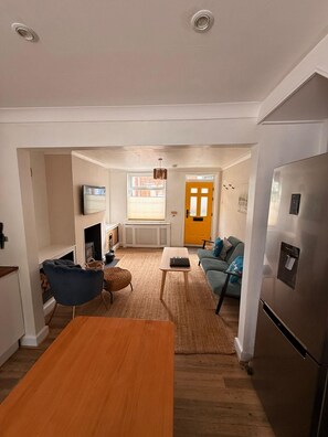 A modern kitchen with a built-in refrigerator, a dining table, and a seating area with a sofa and chairs. - 2 Bed in Beverley (oc-93219) (Beverley)