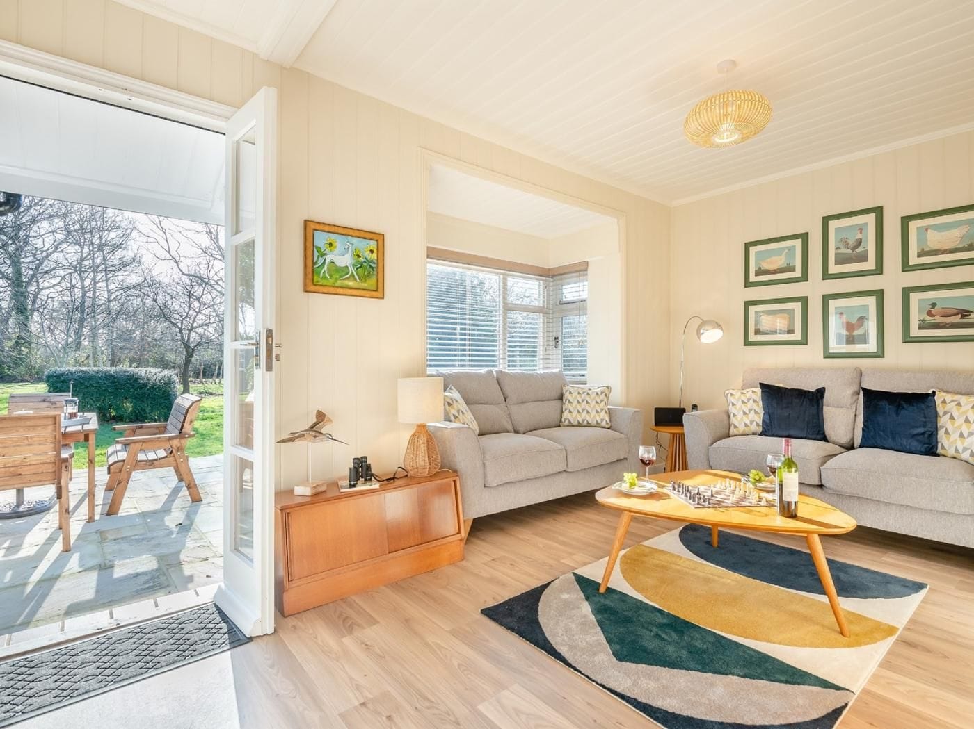 A spacious living room with a sofa, coffee table, and a dining area with chairs.