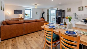 A modern kitchen with a dining area, a sofa, and a TV. - 2 Bed in Ripon (oc-94000) (Littlethorpe)