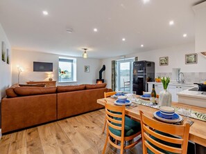 A modern kitchen with a dining area, a sofa, and a TV. - 2 Bed in Ripon (oc-94000) (Littlethorpe)