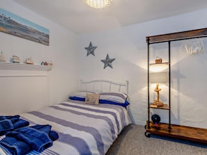 Ein Schlafzimmer mit einem Bett, einer Sterne-Dekoration, einer Ablage mit Flaschen und einer Lampe.