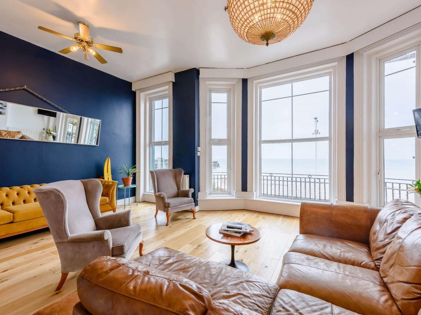 A modern living room with a sofa, armchairs, a coffee table, and a large window with a view.