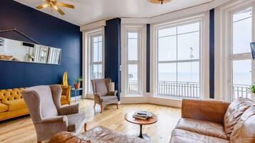 A modern living room with a sofa, armchairs, a coffee table, and a large window with a view.