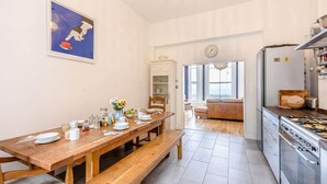 Een eetgedeelte met een houten tafel, banken en uitzicht op de woonkamer.