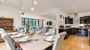 Une cuisine moderne avec un coin repas, des meubles en bois et une grande fenêtre.