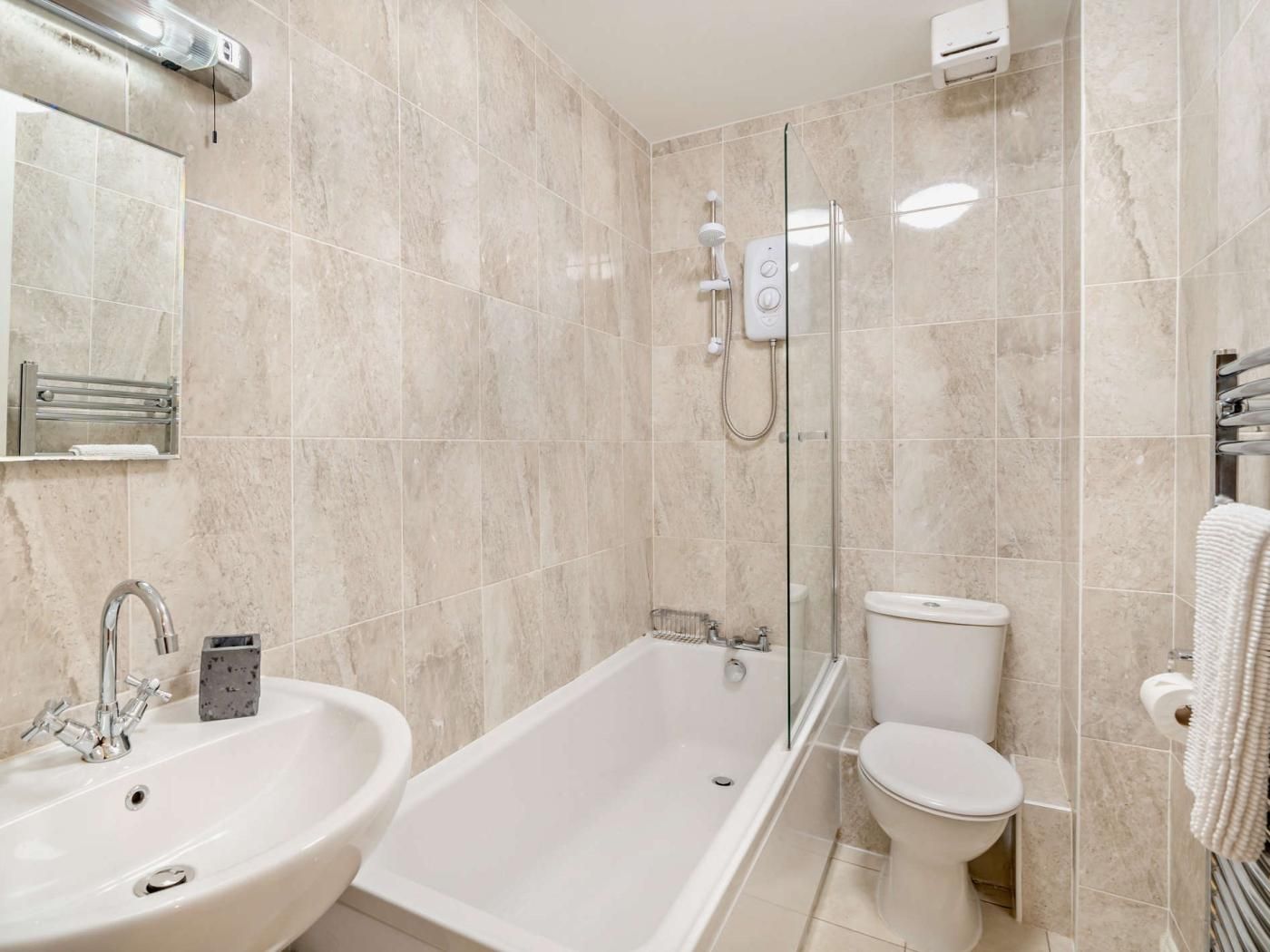 A modern bathroom with a bathtub, a sink, and a toilet.
