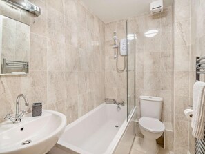 Un baño moderno con bañera, lavamanos e inodoro.