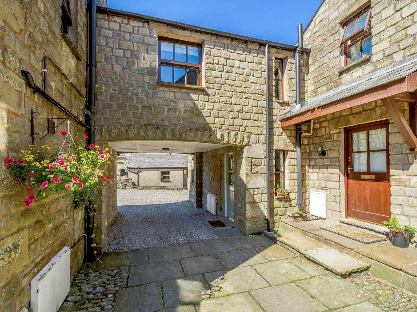 A narrow stone alleyway between two buildings with a small door and a window.