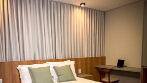 Habitación de hotel con cama, escritorio y una silla.