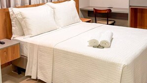 Una habitación de hotel con una cama grande, un escritorio y una silla.