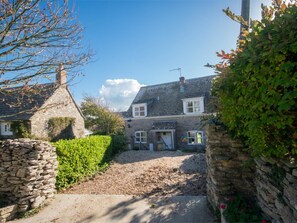 A stone house with a gravel driveway, a stone wall, and a hedge. - 3 Bed in Swanage (oc-dc054) (Worth Matravers)